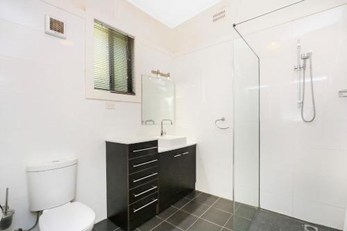 een badkamer met een toilet, een wastafel en een douche bij Townhouse 3 in Broken Hill