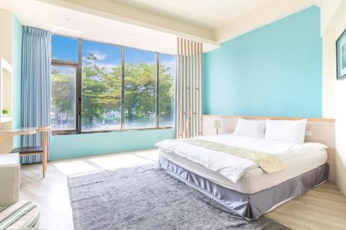 a bedroom with a large bed and large windows at Good time warm home in Tainan