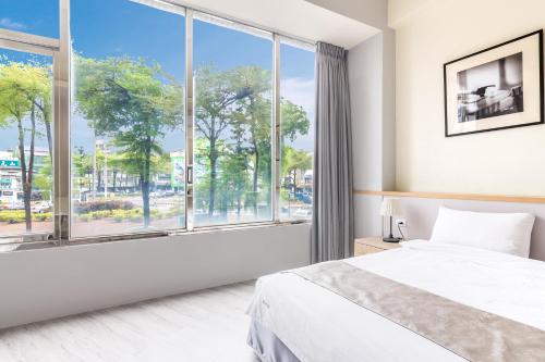 台南的住宿－享樂慢活之輕旅行會館，一间卧室设有一张床和一个大窗户