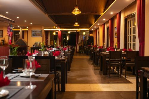 a dining room with tables and chairs with red flowers at Sapa Green Hotel in Sa Pa