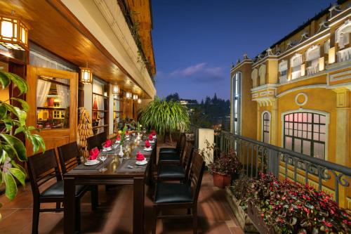 a restaurant with a long table on a balcony at Sapa Green Hotel in Sa Pa