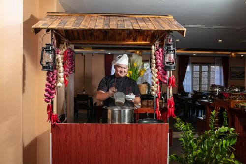 a man is standing in a small kitchen with a pot at Sapa Green Hotel in Sa Pa