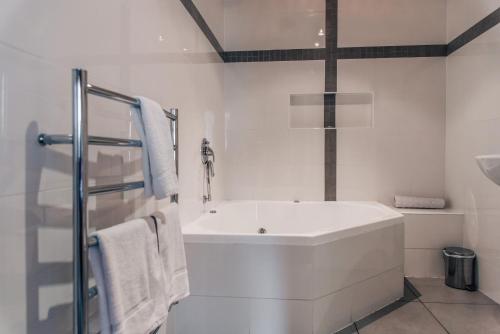 Barossa Valley Apartments في تانوندا: حمام أبيض مع حوض ومغسلة