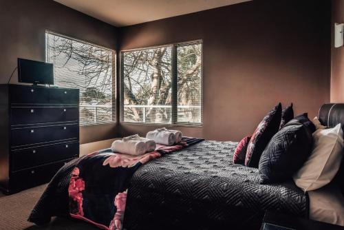 
a bedroom with a bed, a dresser, and a window at Barossa Valley Apartments in Tanunda
