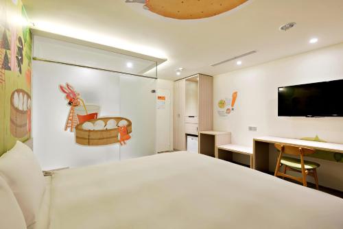 a bedroom with a large white bed and a desk at Whoops Hotel in Taichung