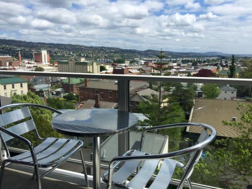 a table and chairs on a balcony with a view at Adina Place Motel Apartments in Launceston