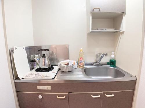 a kitchen with a sink and a counter top at OUCHI HOTEL Takaramachi in Hiroshima