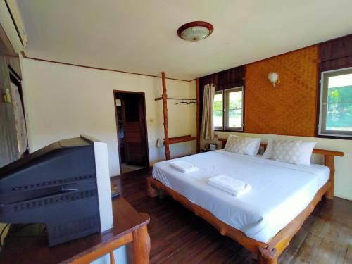 a bedroom with a bed and a flat screen tv at River Kwai Park & Resort in Chongsadao