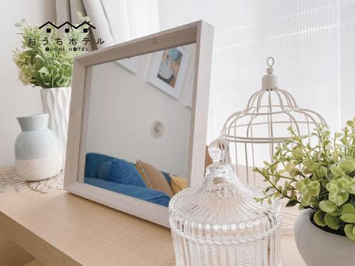a mirror sitting on a desk next to a table with flowers at OUCHI HOTEL Takaramachi in Hiroshima
