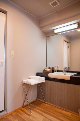 a bathroom with a sink and a mirror at Hotel Kinsuien in Saiki