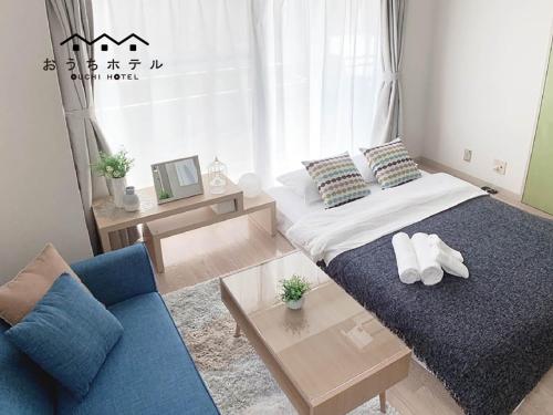 a bedroom with a bed and a blue couch at OUCHI HOTEL Takaramachi in Hiroshima