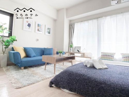 a bedroom with a blue bed and a blue couch at OUCHI HOTEL Takaramachi in Hiroshima