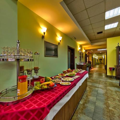 a buffet line with plates of food on a table at Hotel President garni in Zlatibor