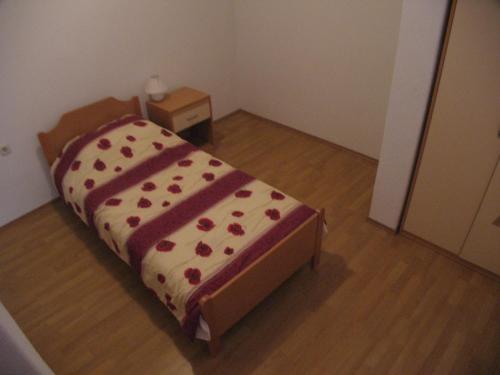 a small bedroom with a bed with red hearts on it at Apartments Jerica in Bol