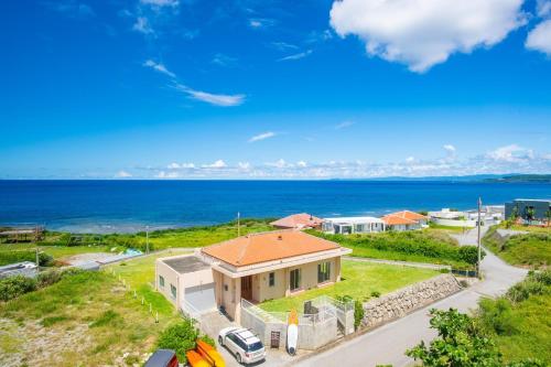 an aerial view of a house with the ocean in the background at Condominium de Urmanchu / Vacation STAY 79737 in Nakijin