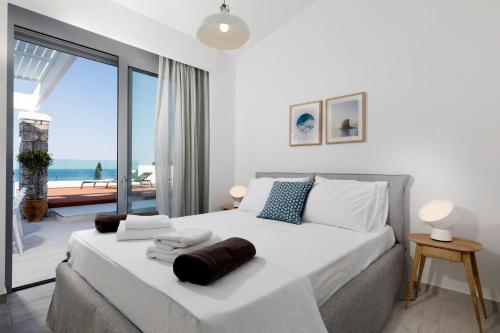 una camera con un grande letto e vista sull'oceano di Villa Estella with pool & jacuzzi in Lindos a Líndos