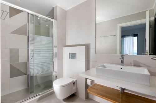 bagno bianco con servizi igienici e lavandino di Villa Estella with pool & jacuzzi in Lindos a Líndos
