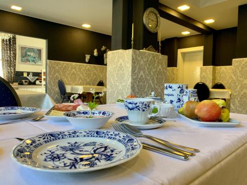 una mesa con platos azules y blancos. en Restaurant und Pension Zur Puppenstube, en Stolpen
