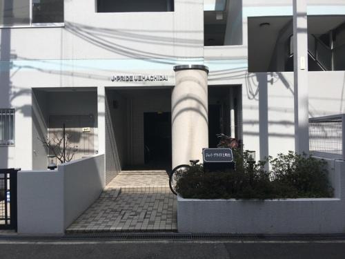a white building with a sign in front of it at Jpride Uemachidai Condo in Osaka