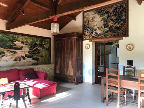 un salon avec un canapé rouge et une table dans l'établissement Presbytère de cassagnes, à Cassagnes