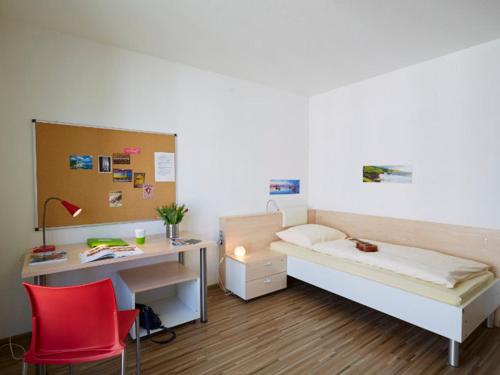 a bedroom with a desk and a bed and a desk and chair at Gästehaus des GOETHE-Institut Freiburg in Freiburg im Breisgau
