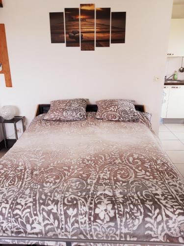 - une chambre avec un lit et une couette marron et blanche dans l'établissement Les jardins d'Antibes, à Antibes