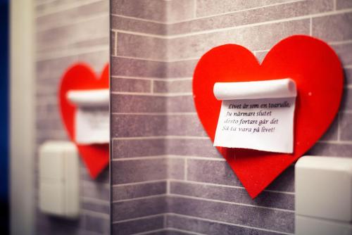 a group of red hearts hanging on a brick wall at Lilla Hotellet in Vilhelmina