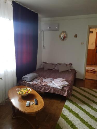 Un dormitorio con una cama y una mesa con un tazón. en Casa Emi, en Orşova
