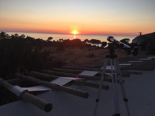 a telescope on a tripod in front of a sunset at Beso Patara in Patara