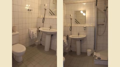 a bathroom with two sinks and a toilet at Hotel Alte Viehweide in Helferskirchen