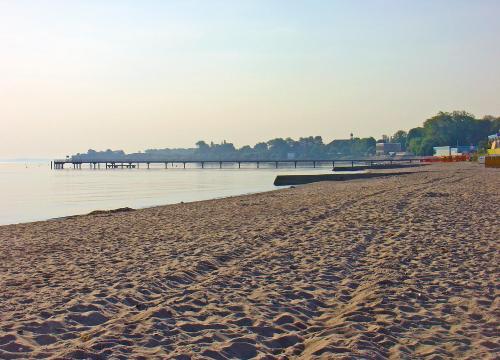 a sandy beach with a pier in the water at Landhaus Dreesen in Timmendorfer Strand