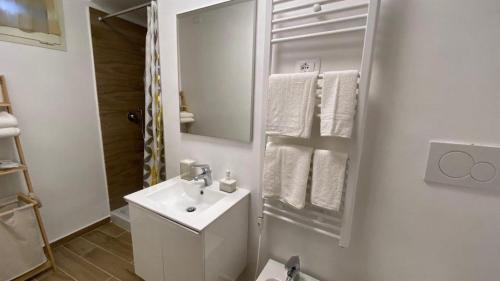 een witte badkamer met een wastafel en een spiegel bij CASA VACANZE LA GIOSTRA in Lettomanoppello
