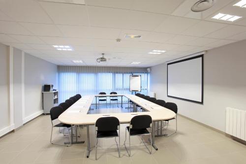a conference room with a large table and chairs at The Originals City, L'Haut' Aile, Coquelles-Calais Tunnel s/Manche L'HAUTAILE in Coquelles