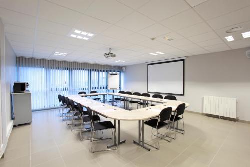 a conference room with a long table and chairs at The Originals City, L'Haut' Aile, Coquelles-Calais Tunnel s/Manche L'HAUTAILE in Coquelles