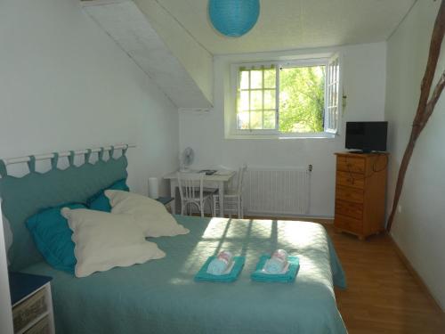 a bedroom with a bed with two pairs of shoes on it at Les chambres du Ladoux in Puy-de-Fourches