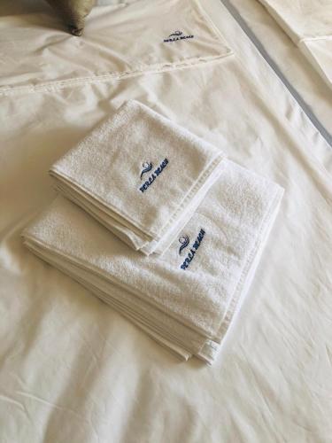 two white towels sitting on top of a bed at Hotel PERLA BEACH in Sozopol