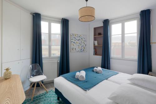 ein Schlafzimmer mit einem Bett mit blauen Vorhängen und einem Stuhl in der Unterkunft Cap à l'Ouest by Cocoonr in Saint-Malo