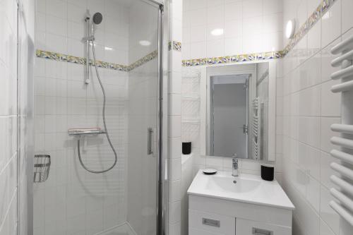 baño blanco con ducha y lavamanos en Cap à l'Ouest by Cocoonr en Saint-Malo