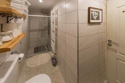 a white bathroom with a toilet and a shower at House Arupium - HOT TUB in Otočac