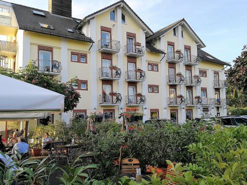 a large building with balconies and tables in front of it at Altes Eishaus, Hotel & Restaurant in Gießen