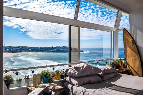 a bedroom with a bed and a large window at Oh My Beach View - Top Floor Paradise by Sydney Dreams Serviced Apartment Bondi in Sydney
