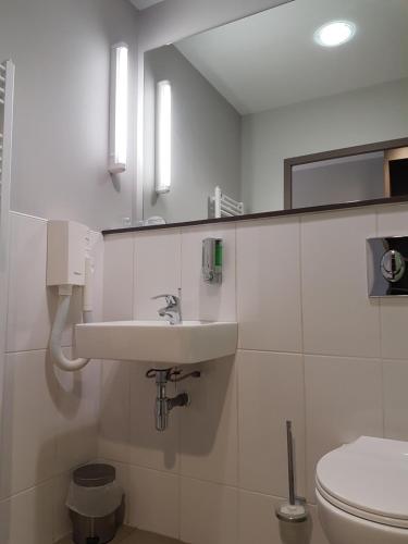 a bathroom with a sink and a toilet at The Originals City, L'Haut' Aile, Coquelles-Calais Tunnel s/Manche L'HAUTAILE in Coquelles