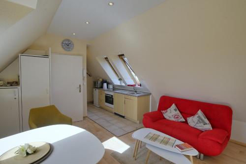 a living room with a red couch and a table at Landhaus Dreesen in Timmendorfer Strand