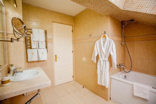 a bathroom with a sink and a robe hanging on the wall at СПА-Готель "RESPECT" in Skhidnitsa
