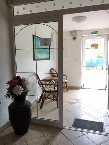 a room with a glass door with a vase with flowers at Guest House Maxim in Liptovský Mikuláš