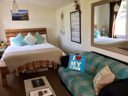 a room with a bed and a couch and a mirror at Southern Scenic Stargazer in Riverton