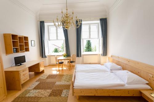una camera con due letti e un lampadario a braccio di Schloss Gumpoldskirchen a Gumpoldskirchen