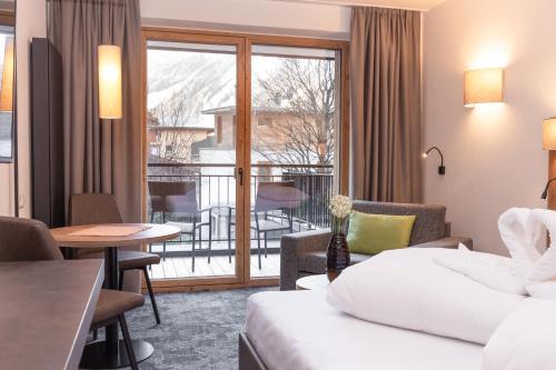 ein Hotelzimmer mit einem Bett und einem Balkon in der Unterkunft Apart Peppone in Längenfeld