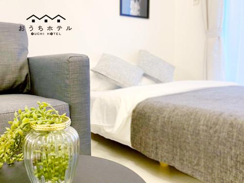 a bedroom with a bed and a vase on a table at OUCHI HOTEL Higashi-Hiratsuka #301 in Hiroshima