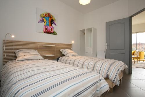 a bedroom with two beds and a picture on the wall at Agréable maison de ville in Périgueux